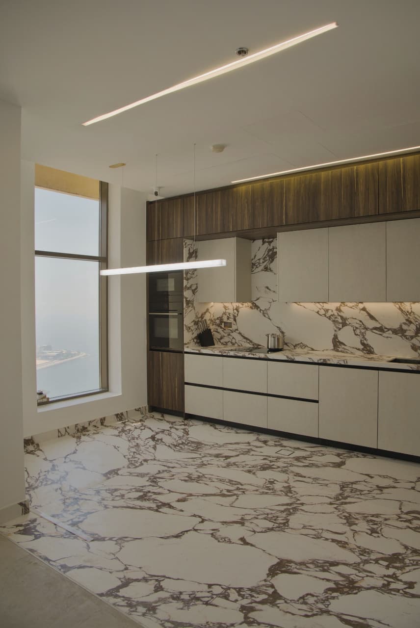 Residential kitchen interior design with marble and walnut in JBR, Dubai